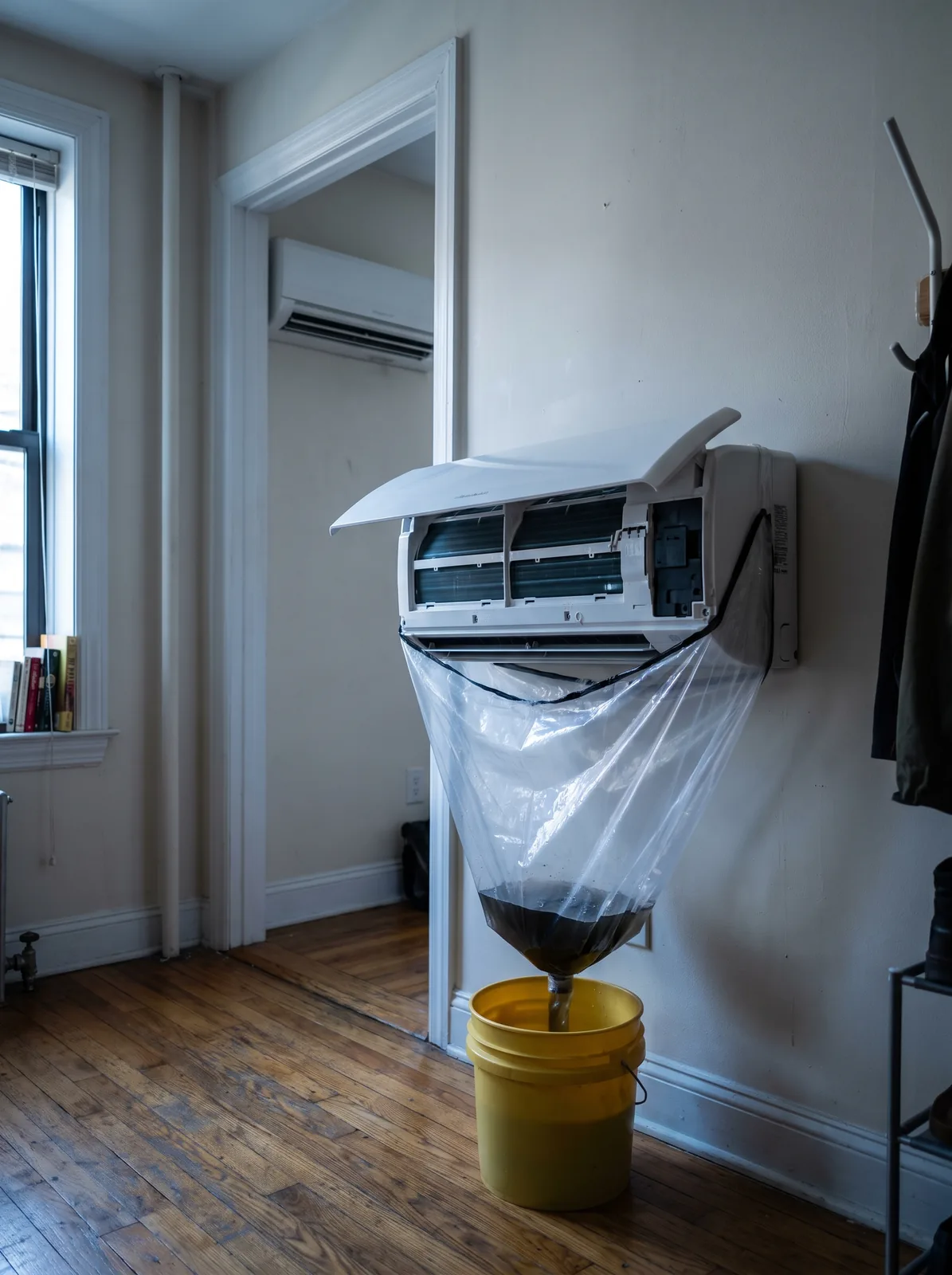 Two mini-split heads in one apartment, the nearer one bagged for cleaning