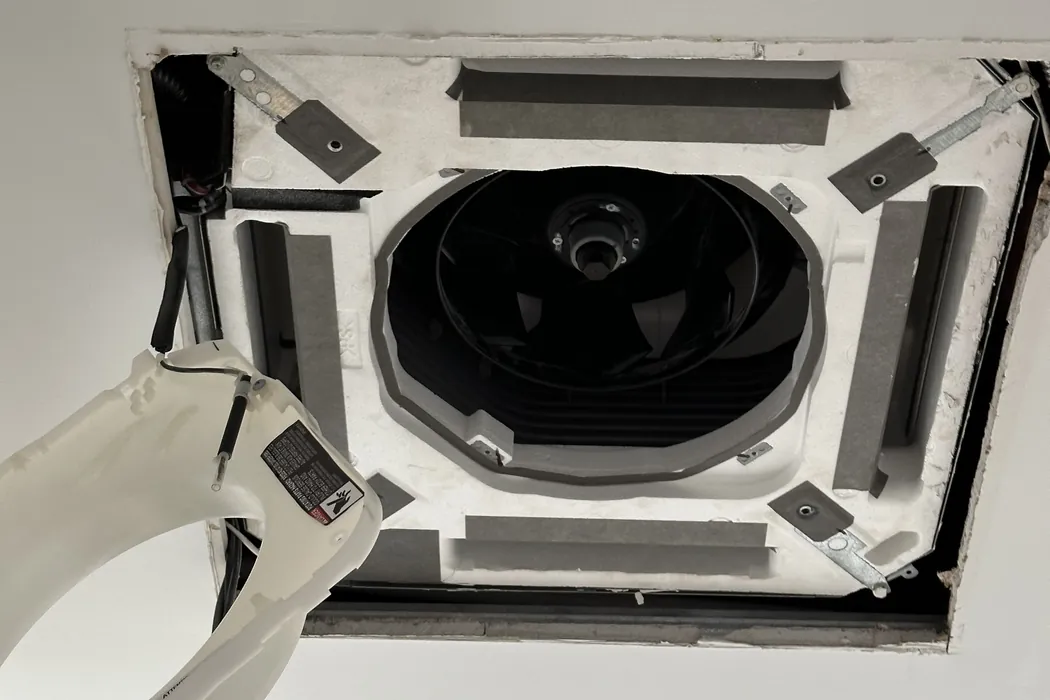 Fan drum and coil visible inside an opened ceiling cassette