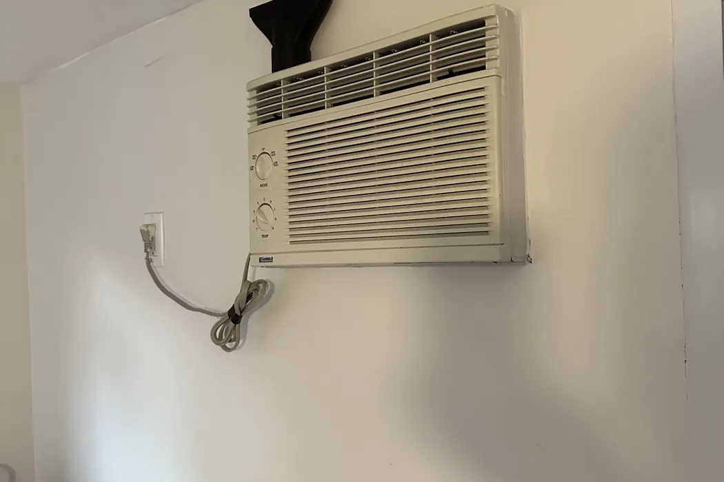 Through-the-wall air conditioner seated in its sleeve in an apartment wall